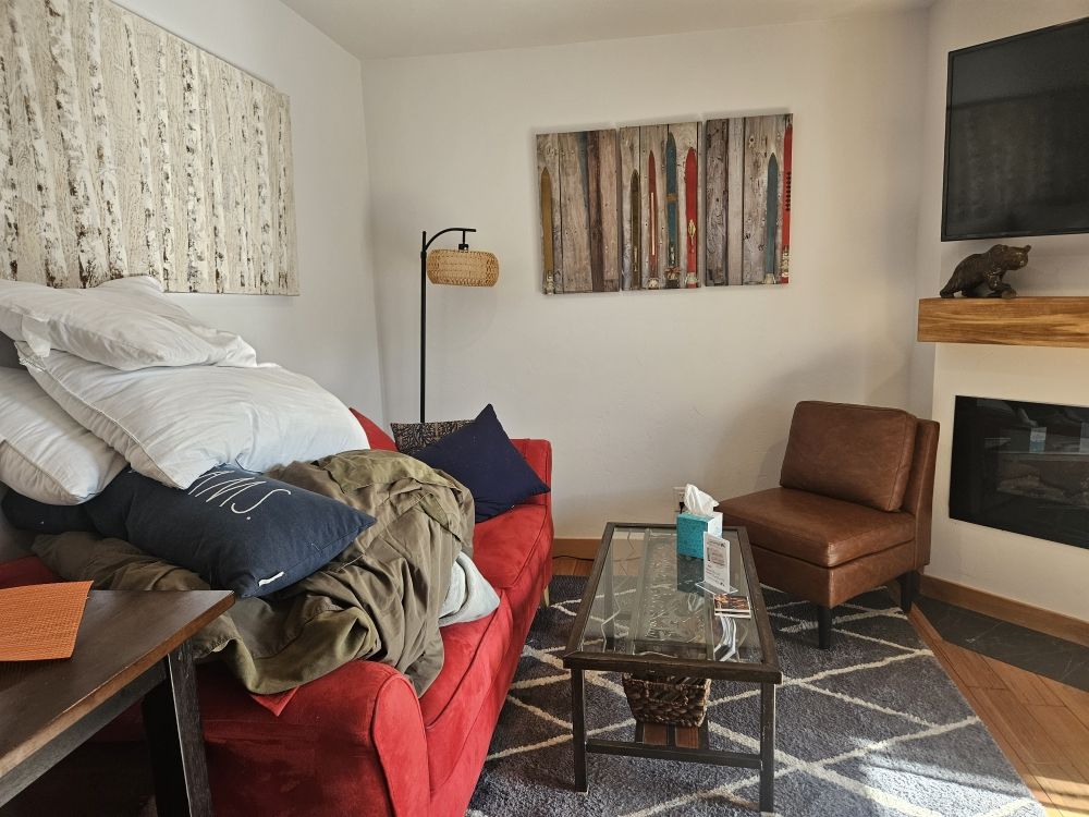A cozy living room featuring a couch, coffee table, and a fireplace, highlighting cleaning services for a tidy space.