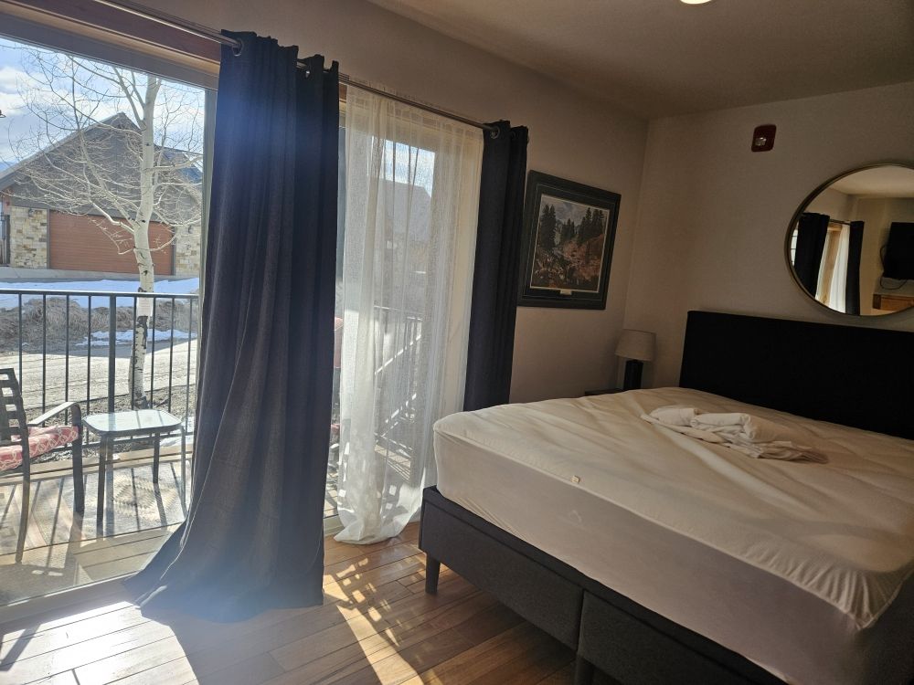 A cozy bedroom featuring a bed and a balcony, highlighting the availability of cleaning services.